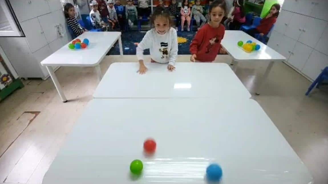 Minik dahiler sınıfı oyun dersinde topları yuvarlayıp banta yapıştırma oyununu eğlenerek oynadılar.